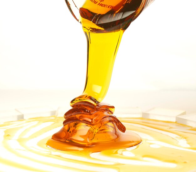 Pouring golden honey on a white background