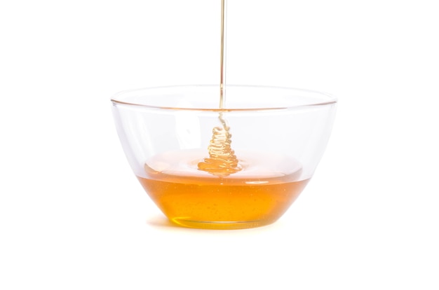 Pouring honey into a glass bowl