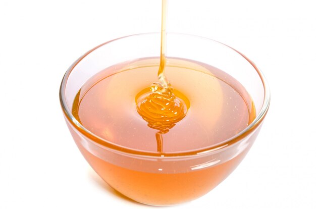 Pouring honey into a glass bowl