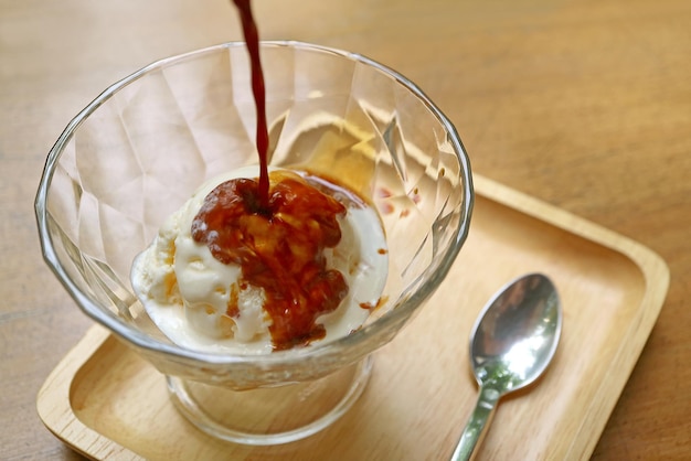 Pouring hot espresso onto vanilla ice cream for an aromatic and tasty Affogato