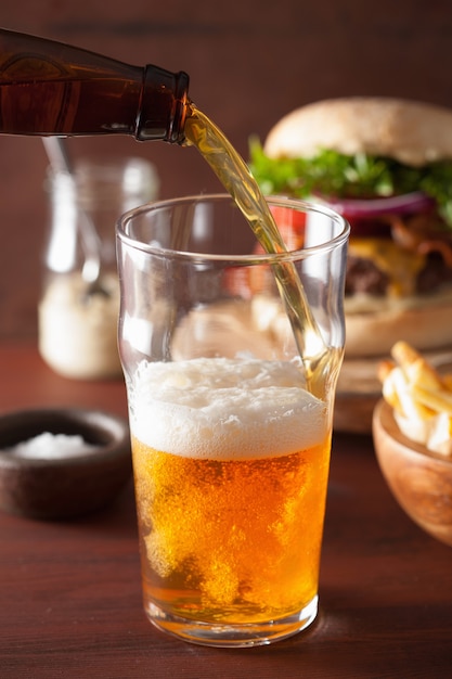 Pouring india pale ale beer into pint glass and fastfood