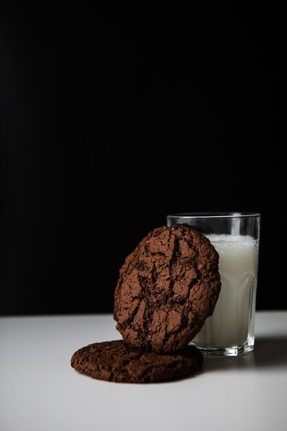 Pouring milk in glass with chocolate cookies