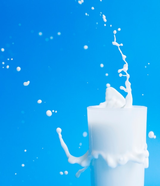 Photo pouring milk out of glass