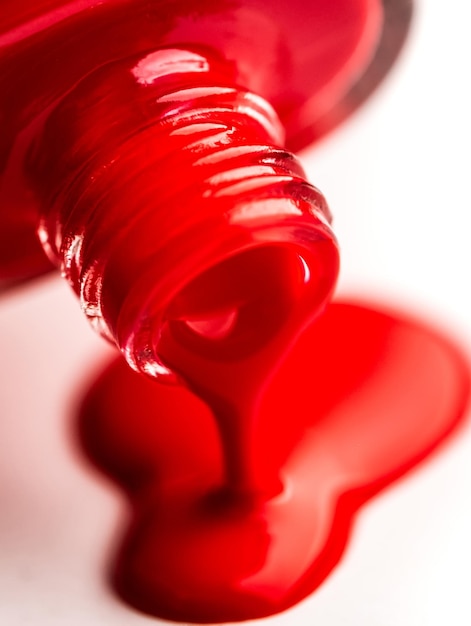 Photo pouring nail polish from bottle