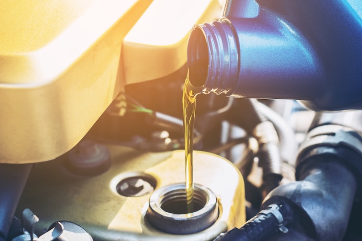 Photo pouring oil to car engine