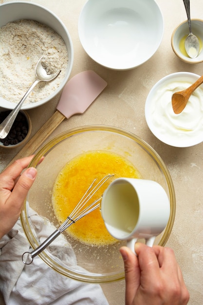 Pouring oil over eggs in glass bowl. Cooking a cake in glass bowl, top view. Step by step recipe.