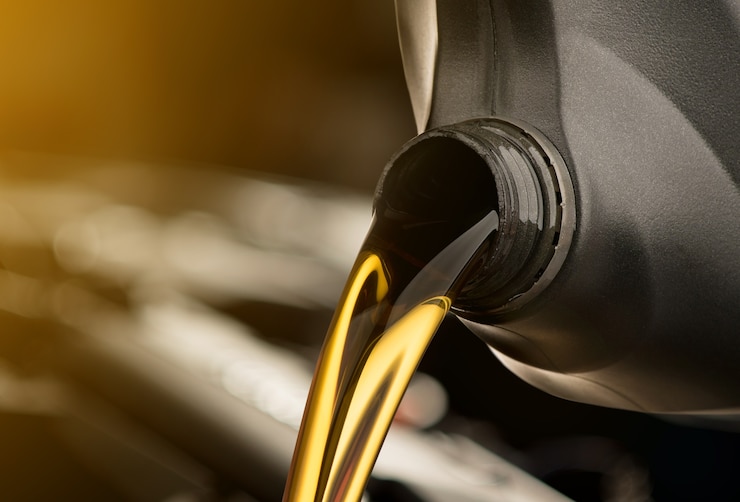 Photo pouring oil lubricant motor car from black bottle on isolated white background