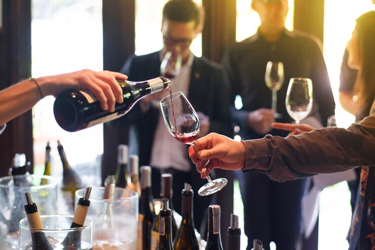 Photo pouring red wine from the bottle into glasses