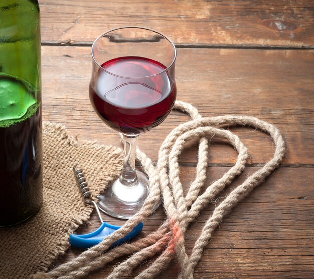 Pouring red wine glass against wooden table