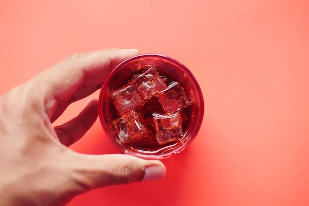 Pouring soft drinks in a glass with ice cube