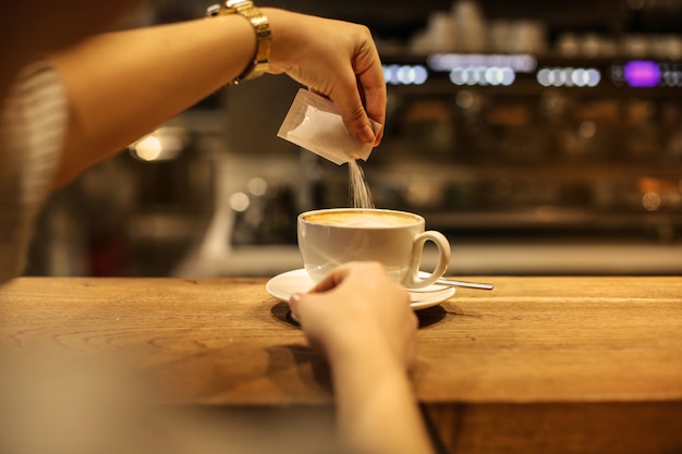 コーヒーに砂糖を注ぐ