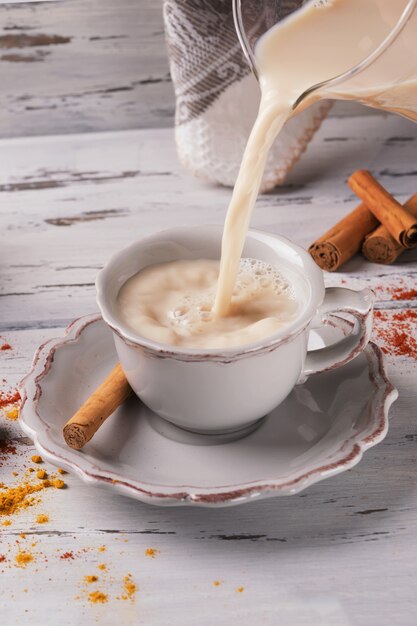 Pouring traditional indian hot tea with spices