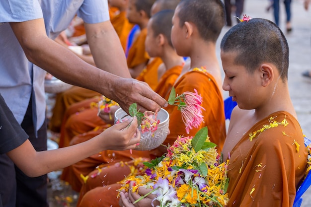 Photo pouring water to buddhist novice