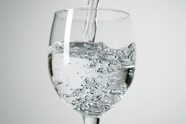 pouring water on a glass on white background