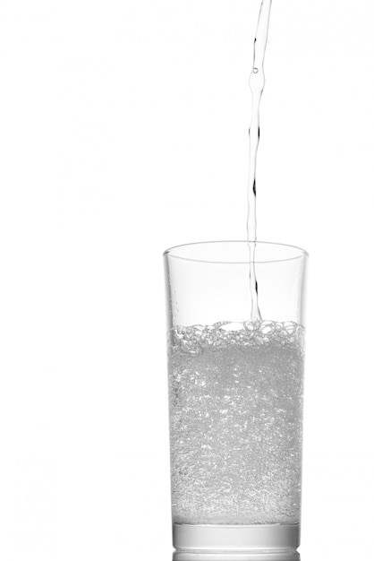 Pouring water into a glass isolated on white