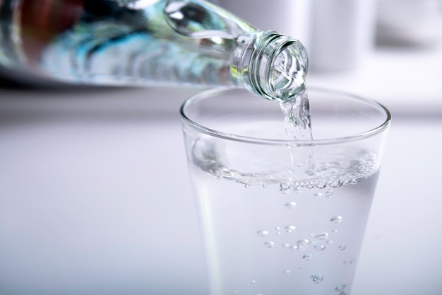 Pouring water into glass in the kitchen