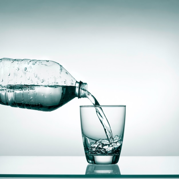 Pouring water into transparent glass