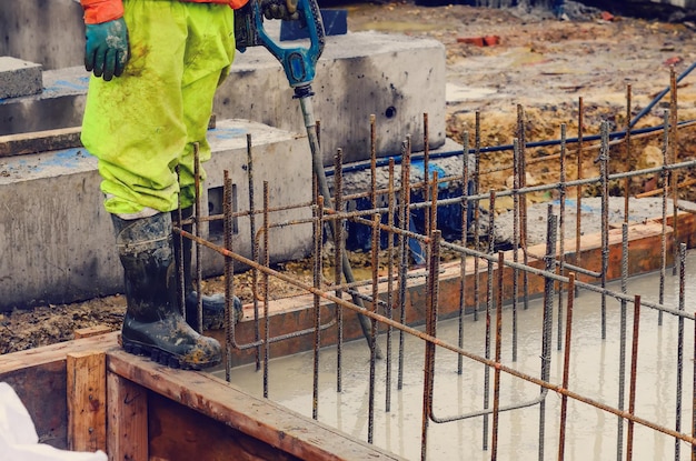 Pouring wet readymix concrete into lift pit base and levelling it