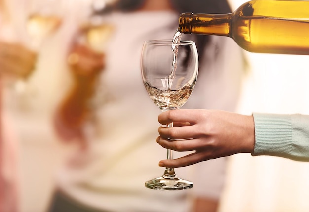 Pouring white wine into glass at henparty close up