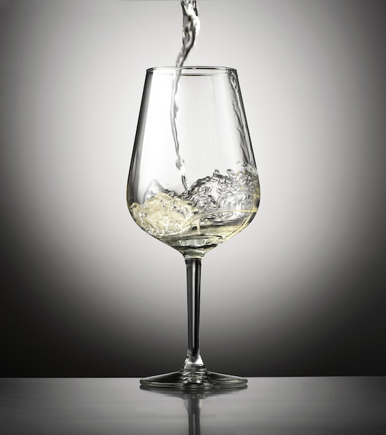 Pouring white wine into a wineglass