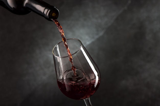 Photo pouring wine from bottle to glass