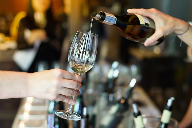 pouring wine from the bottle into glasses