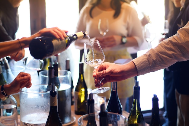 pouring wine from the bottle into glasses