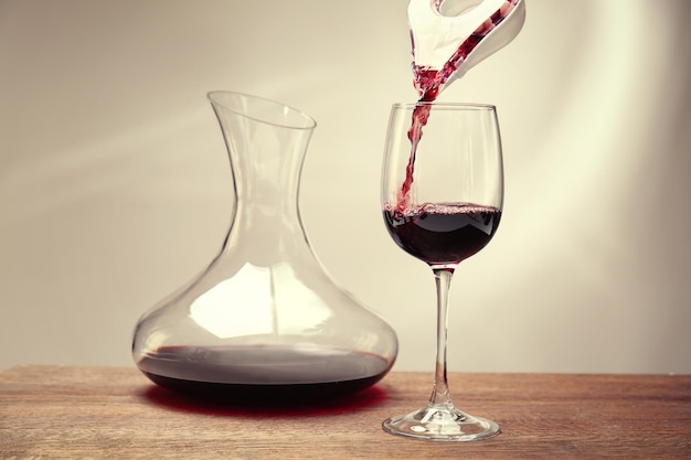 Pouring wine in glass on wooden table