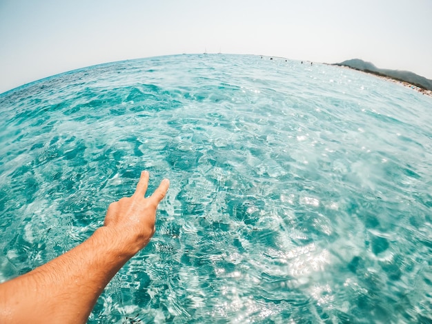 Foto pov e prima vista di una persona che nuota nell'acqua della spiaggia nel mare nel blu