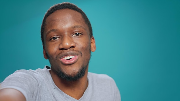 POV of male vlogger talking on online videocall with webcam, holding modern smartphone. Young man doing vlog content with videoconference meeting on network, remote conversation.