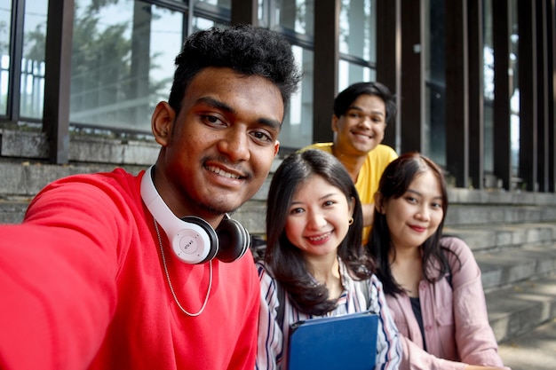 POV of Multicultural college students having fun taking selfie picture smiling using smartphone