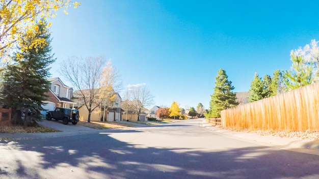 POV point of view - Driving through typical suburban residential neighborhood in Autumn.