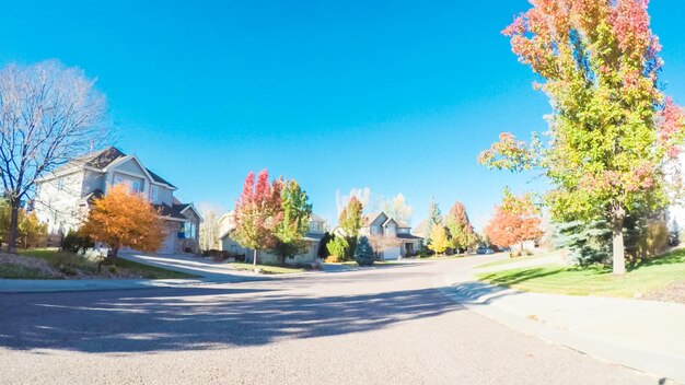 POV point of view - Driving through typical suburban residential neighborhood in Autumn.