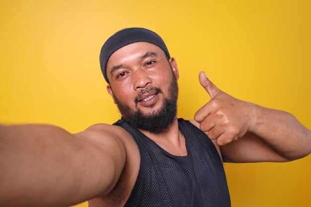 POV shot of a sporty bearded man looking at the camera taking a selfie with thumbs up