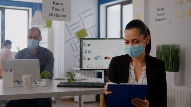 Pov van zakenvrouw met medisch gezichtsmasker die werkt aan communicatieproject met team tijdens online videoconferentie. Ondernemer op web internet videogesprek in nieuwe normale bedrijfsruimte