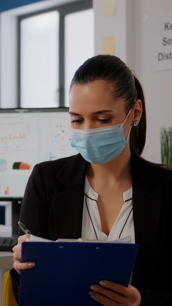 Pov van zakenvrouw met medisch gezichtsmasker die werkt aan communicatieproject met team tijdens online videoconferentie