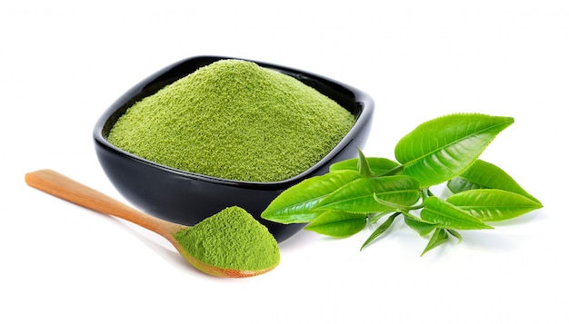Порошок зеленого чая и листьев зеленого чая на белом