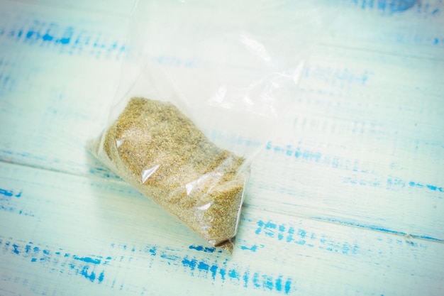 Powder in a plastic bag on a wooden background Ground mixture of herbs
