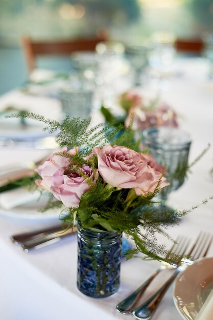 Powder roses in small blue vasesWedding decor or romantic date design Floristics