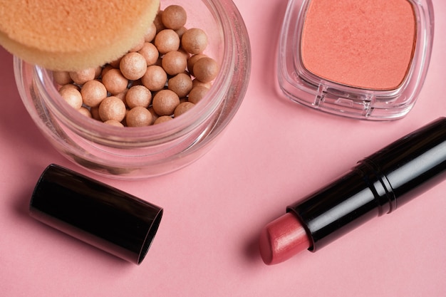 Powder with lipstick on a pink background