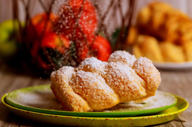 Strudel alle mele in polvere sul piatto verde con le mele fresche