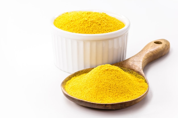 Powdered curry with spoon and bowl on isolated white background