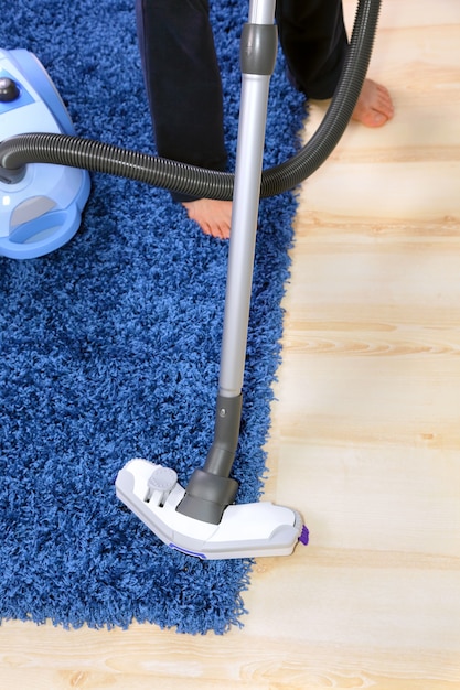 Powelful vacuum cleaner in action-a men cleaner a carpet.