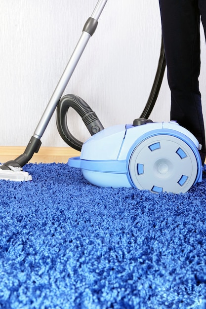 Photo powelful vacuum cleaner in action-a men cleaner a carpet.