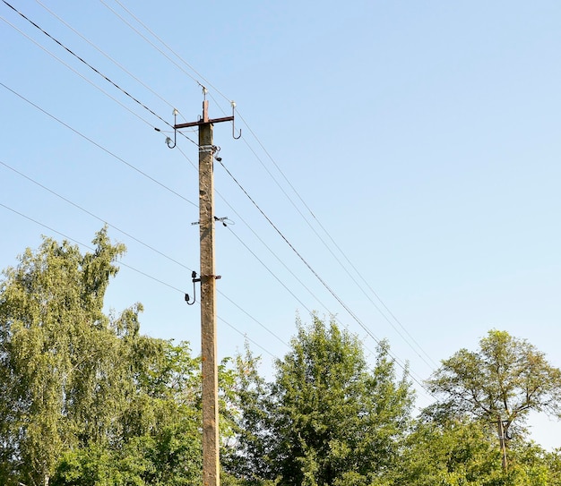 色付きの背景にライン ワイヤと電力電柱を住宅用建物の電力電柱のスカイライン線の下にライン ワイヤと電力電柱から成る写真をクローズ アップ