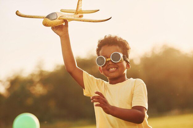 Power of imagination Playing pilot game African american kid have fun in the field at summer daytime