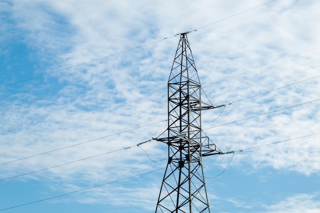 Power line-ondersteuning op de achtergrond van een blauwe lucht met wolken