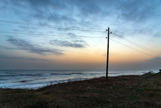 Foto pilastro della linea elettrica lungo il mare