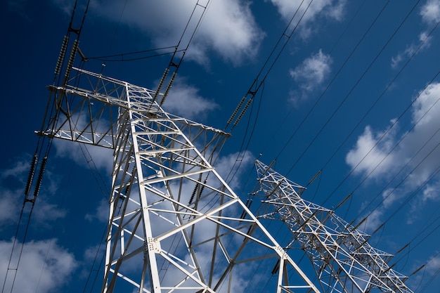 Foto power line toren op een achtergrond van blauwe lucht met wolken.