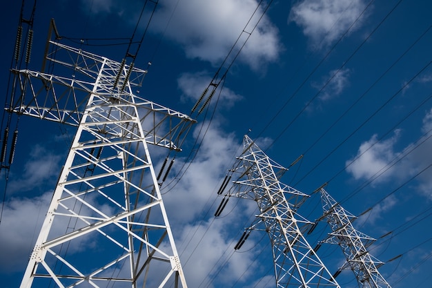 Power line tower on a of blue sky with clouds.